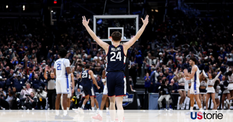 UConn players celebrating on the court after a last-second game-winning shot against Duke in the Elite Eight.