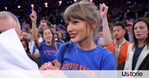 Taylor Swift wearing a blue Stevie Knicks shirt celebrating courtside alongside Ben Stiller at Madison Square Garden during Game 4 of the NBA Finals.